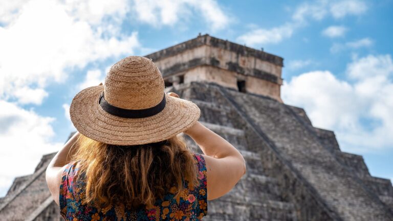Voyageuse portant un chapeau devant la pyramide de Chichén Itzá