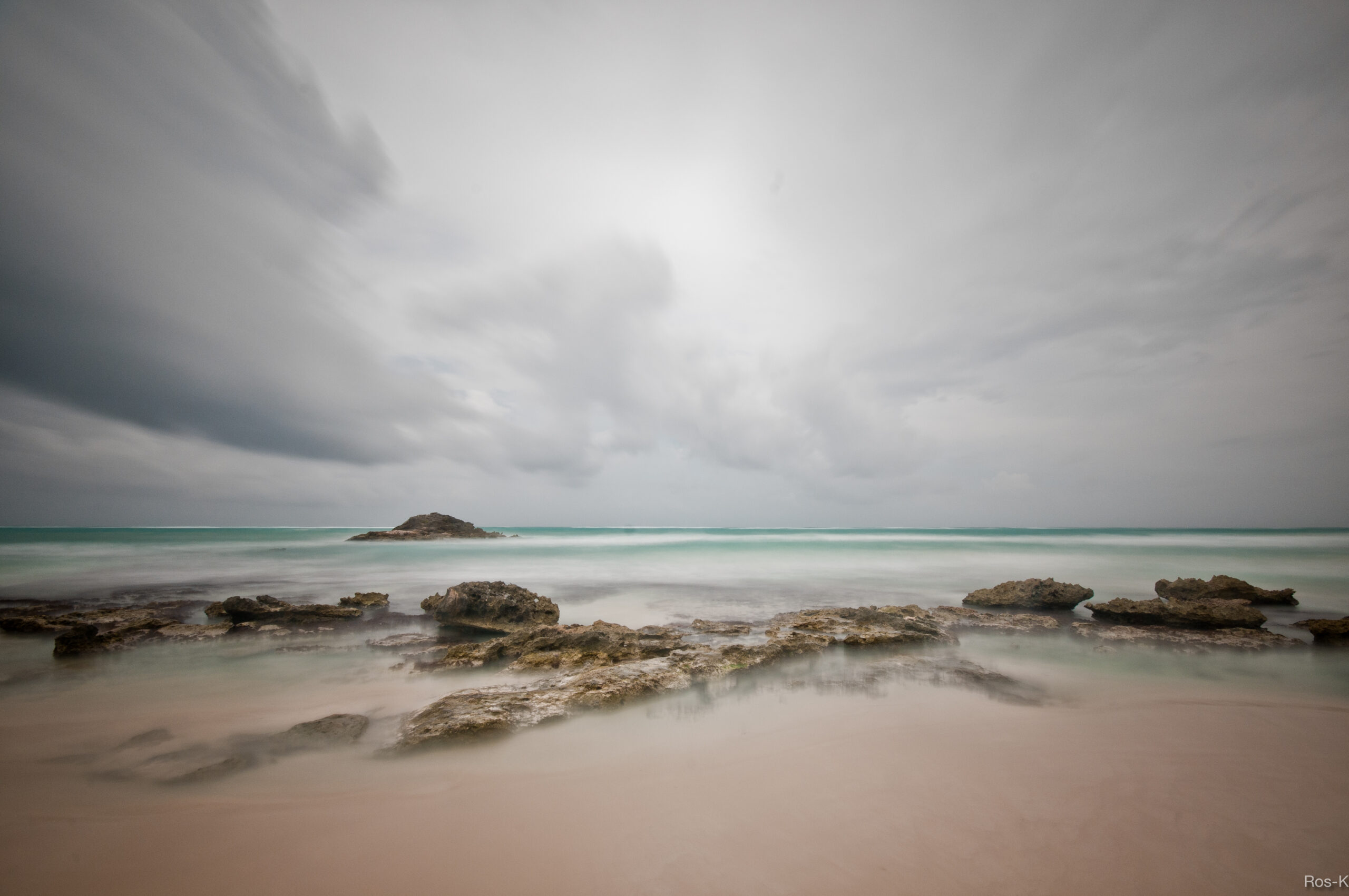 Dark clouds over the sea and rocks on a Tulum beach